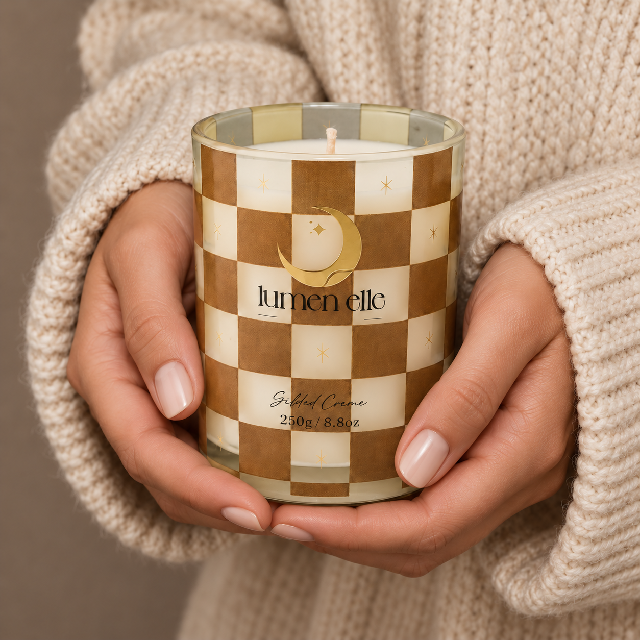 Lumenelle Gilded Crème candle held in two hands
