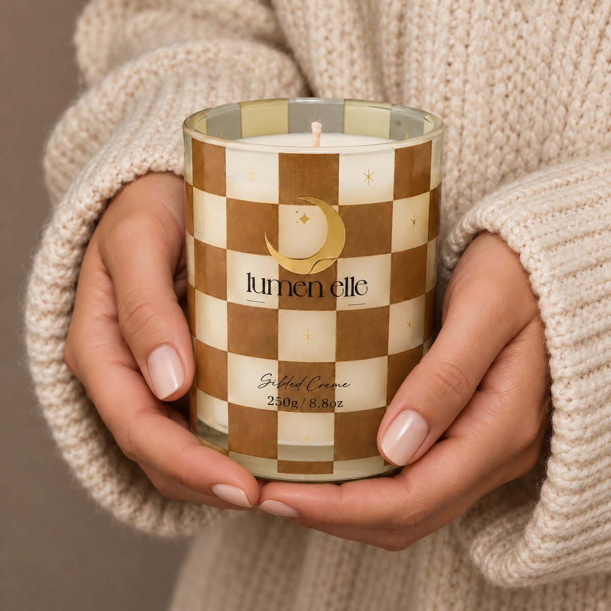 Lumenelle Gilded Crème candle held in two hands
