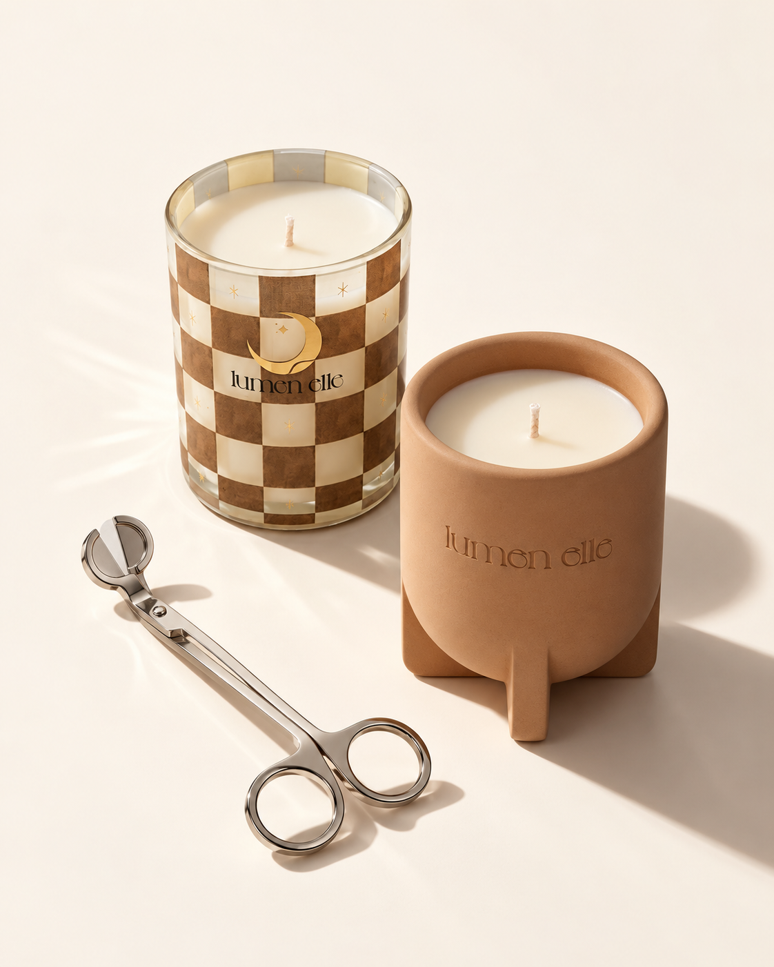 Lumenelle Sugar Arcade and Sunlit Atrium candles with a wick trimmer on a pale surface